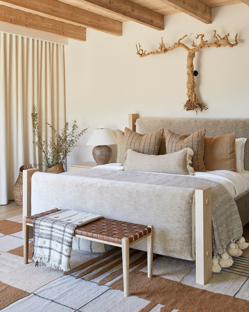 Woven leather bench with saddle-colored straps and teak frame in wine country bedroom