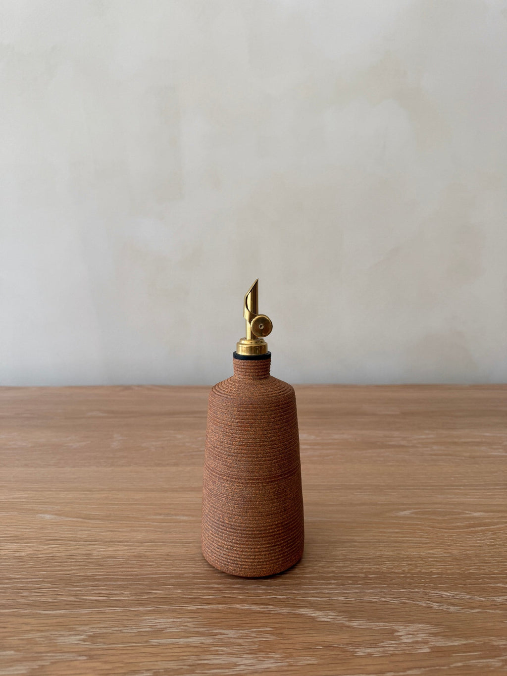 Lucca Ceramic Vinegar Bottle in terracotta with ribbed texture and brass pour spout