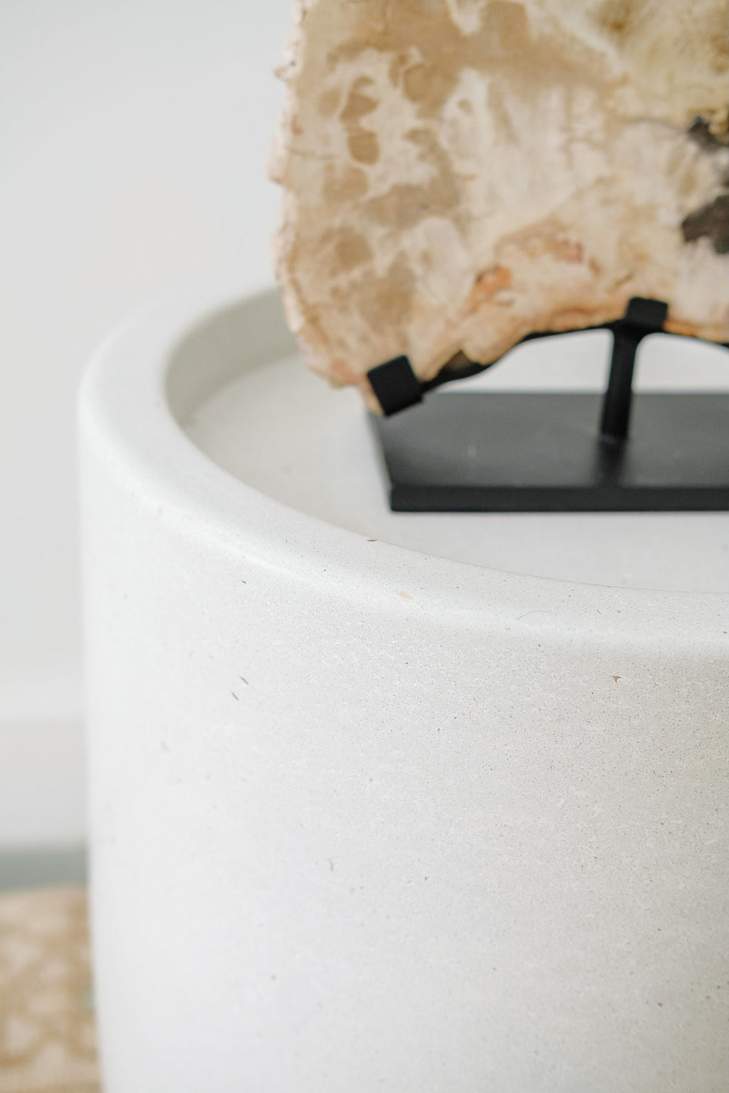 Close-up of smooth white abalone terrazzo side table with decorative stone on top