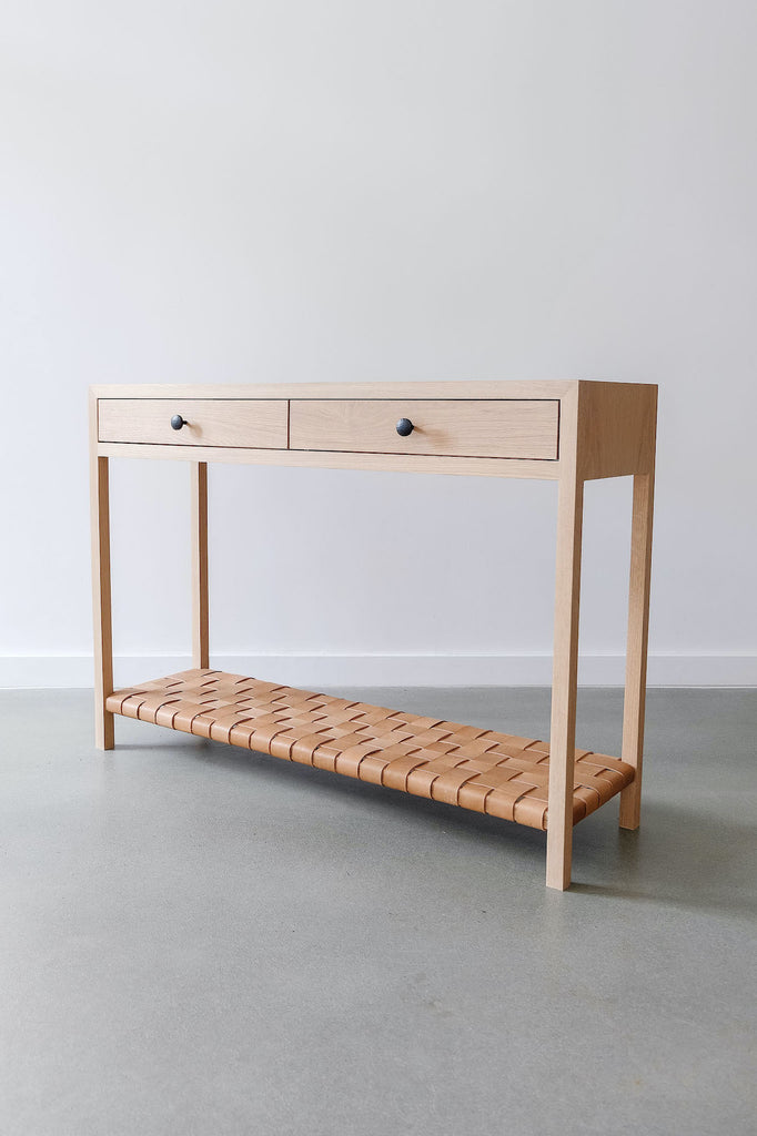 Angled view of White Oak Leather Strap Console Table against a white wall. - Saffron and Poe