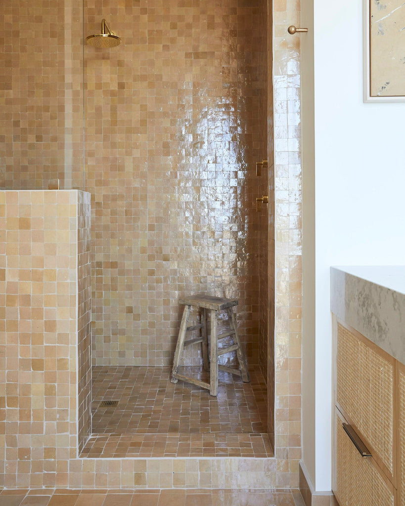 Vintage antique stool made of solid elmwood inside a tiled shower space