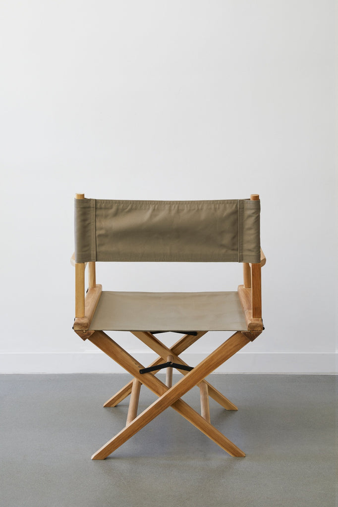 Back view of Taupe Canvas Director's Chair against white background on concrete flooring. - Saffron and Poe