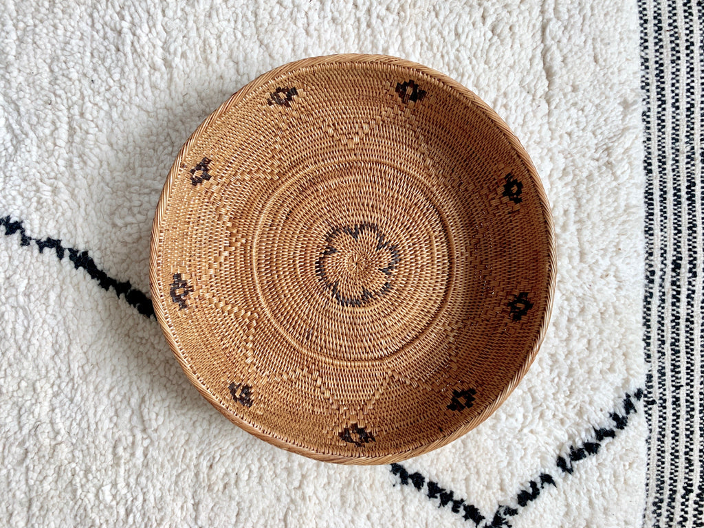 Detailed view of our Black and Natural Tenganan Basket on a white and black rug. Handwoven using Ata reed.- Saffron and Poe