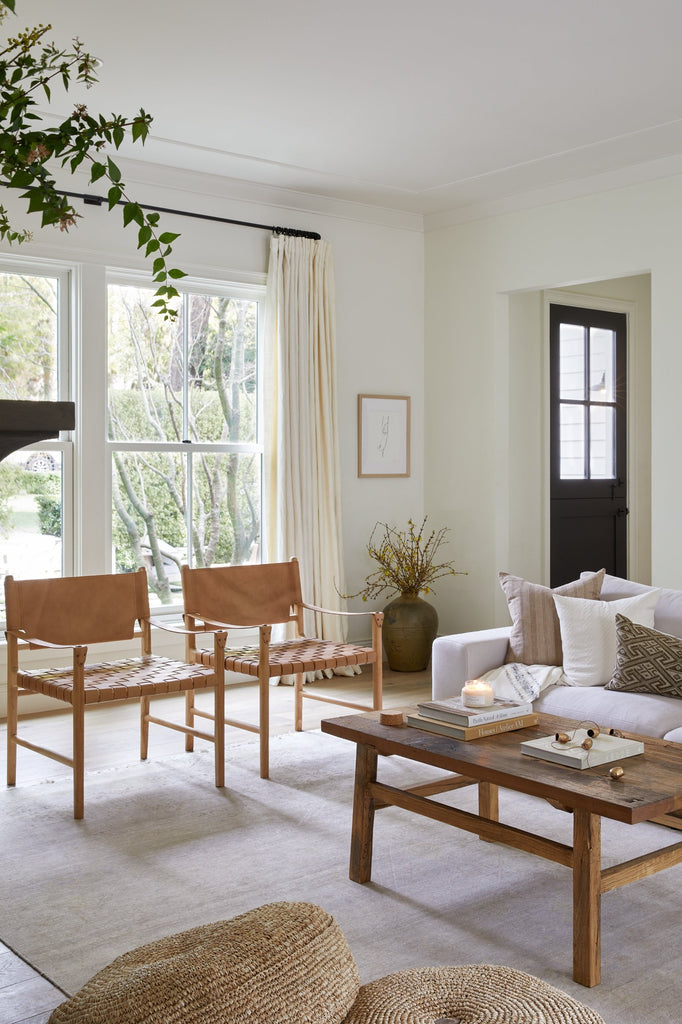 Leather Safari Chair in a living room setting with Vintage Coffee Table and Natural Pouf. - Saffron + Poe