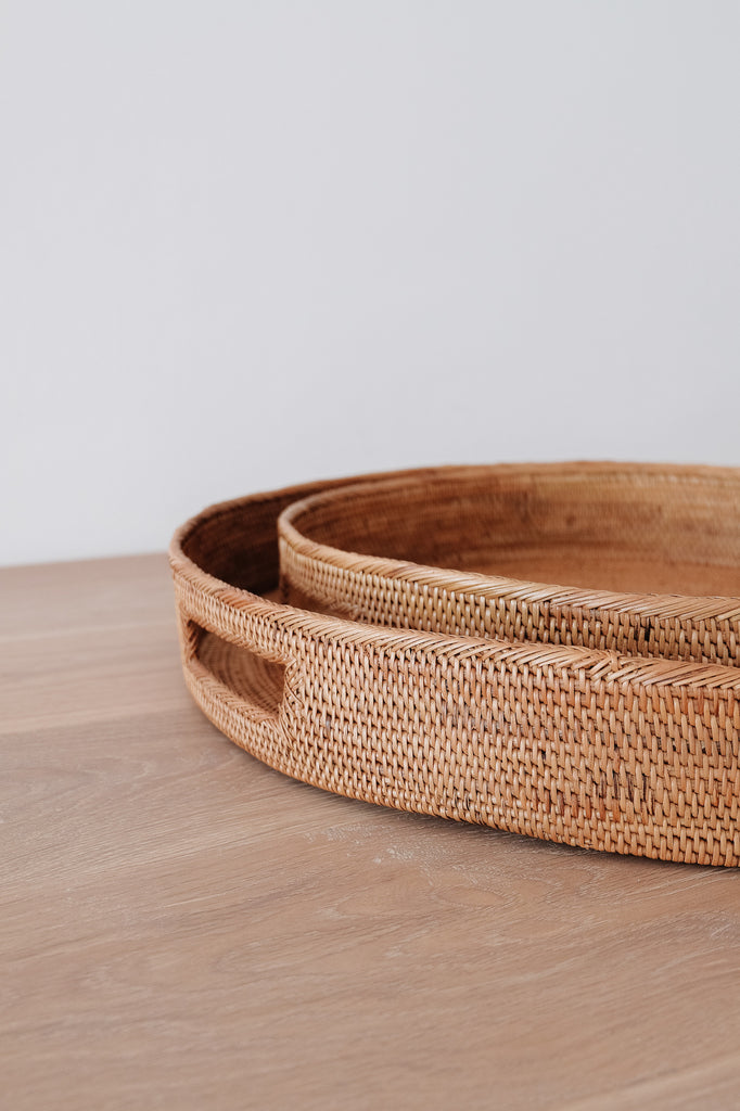 Close up of Round Tenganan Basket Trays on a white oak table against a white wall. - Saffron and Poe