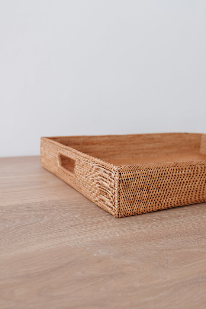 Close up view of Tenganan Basket Tray on a white oak table against a white wall. - Saffron and Poe