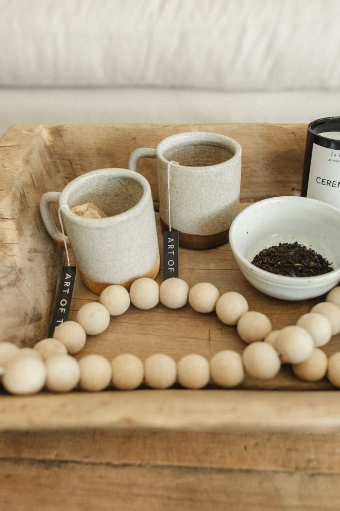 Close up view of Uzumati Ceramic Bodie Mug and Snow Creek Mug styled with Wooden Bali Beads - Large - Saffron and Poe