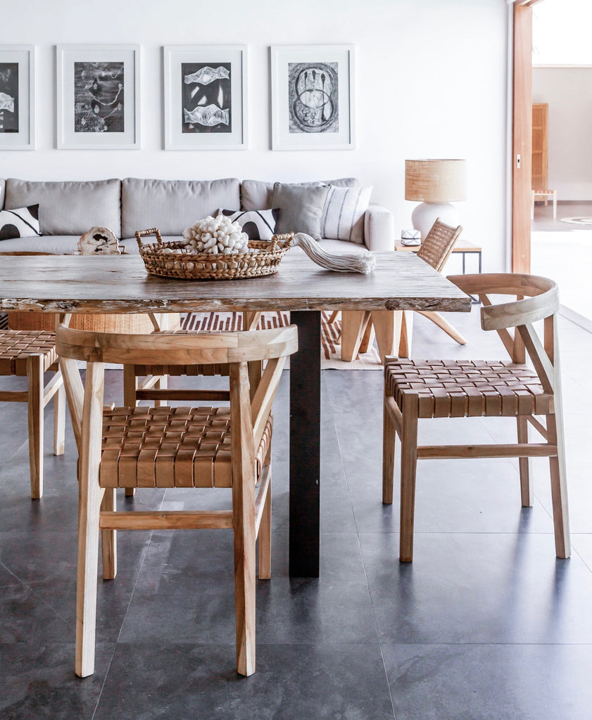 Three curved wood and woven beige leather dining chairs inspired by the wishbone Chair at kitchen table. Handcrafted in Bali with Teak wood and vegetable-tanned leather imported from Java. - Saffron and Poe