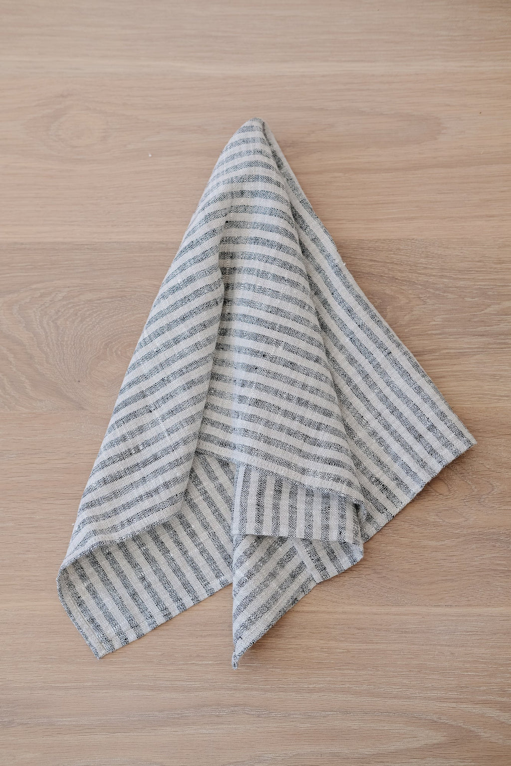 Small stripe linen hand towel made from high-quality European flax linen on wooden surface