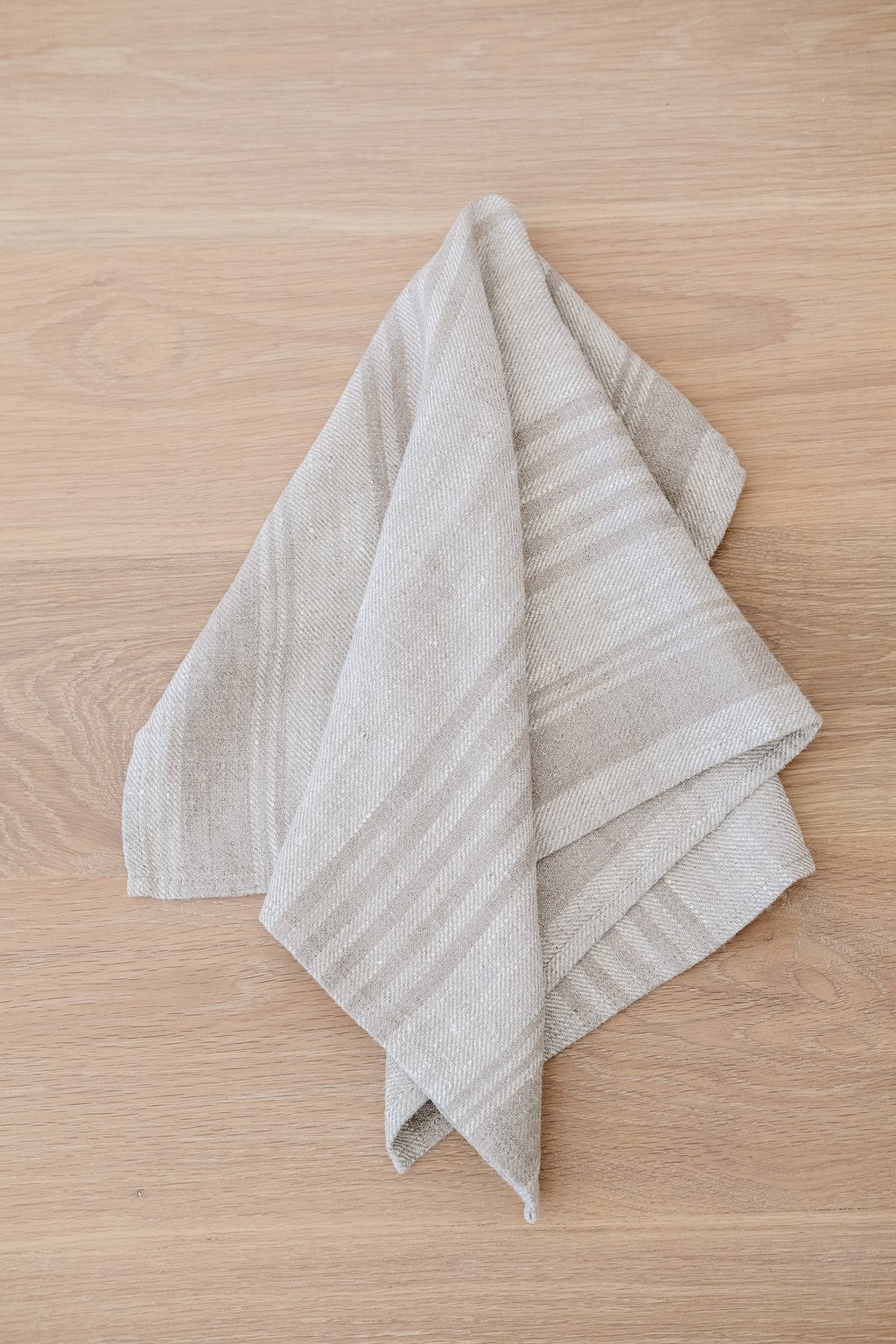 Natural stripe linen hand towel made from high-quality European flax linen on wooden surface