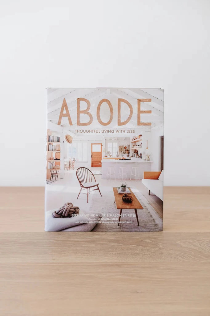 Front cover of Abode book against a white background on an oak table. - Saffron and Poe