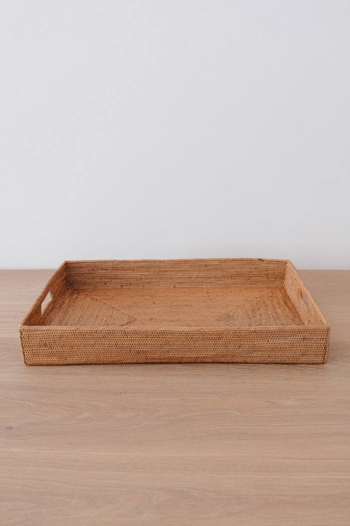 Front view of Tenganan Basket Tray on a white oak table against a white wall. - Saffron and Poe
