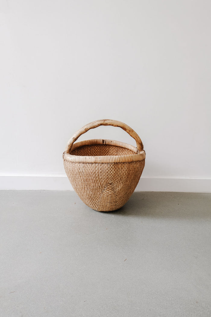 Front view of Chinese Basket against a white wall. - Saffron and Poe