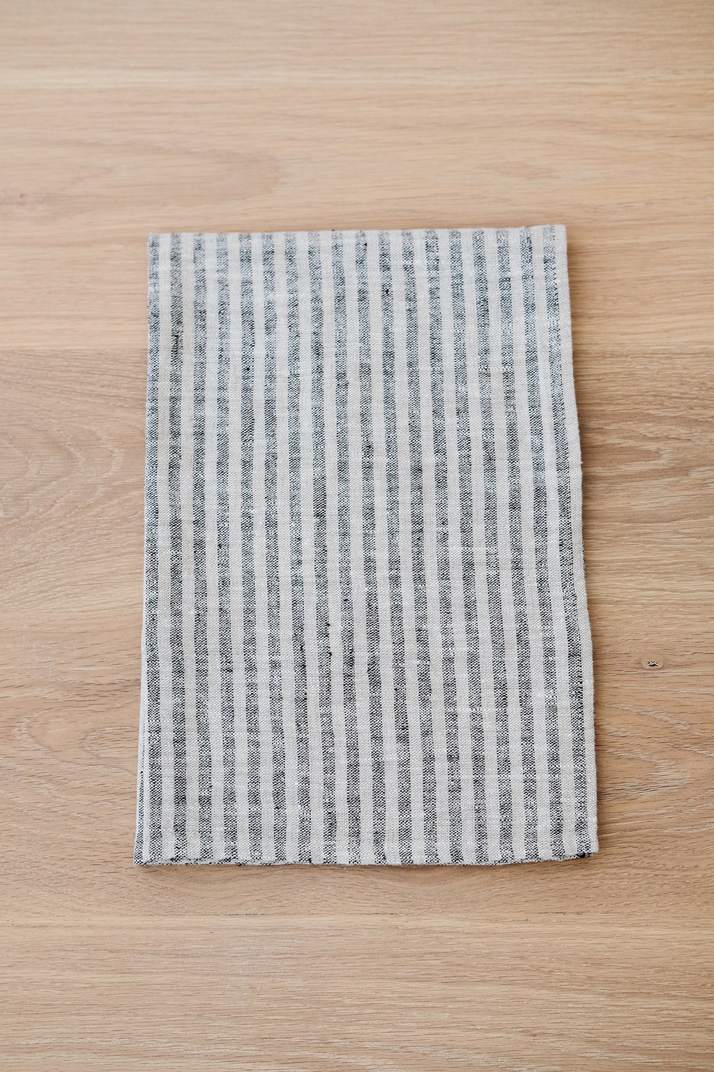 Small stripe linen hand towel on wooden surface