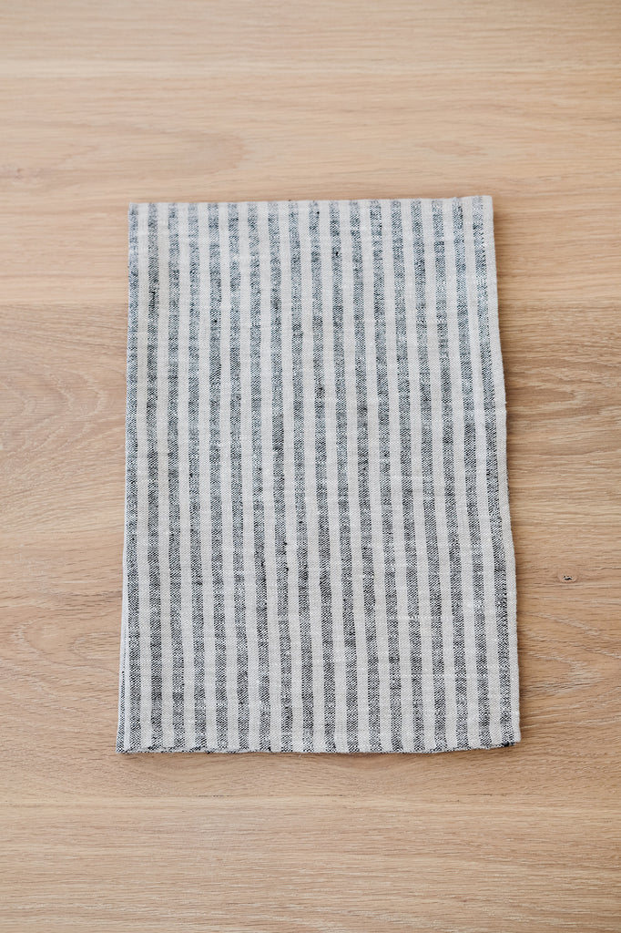 Folded Small Stripe Linen Hand Towel (Set of 2) on a White Oak Dining Table. - Saffron and Poe