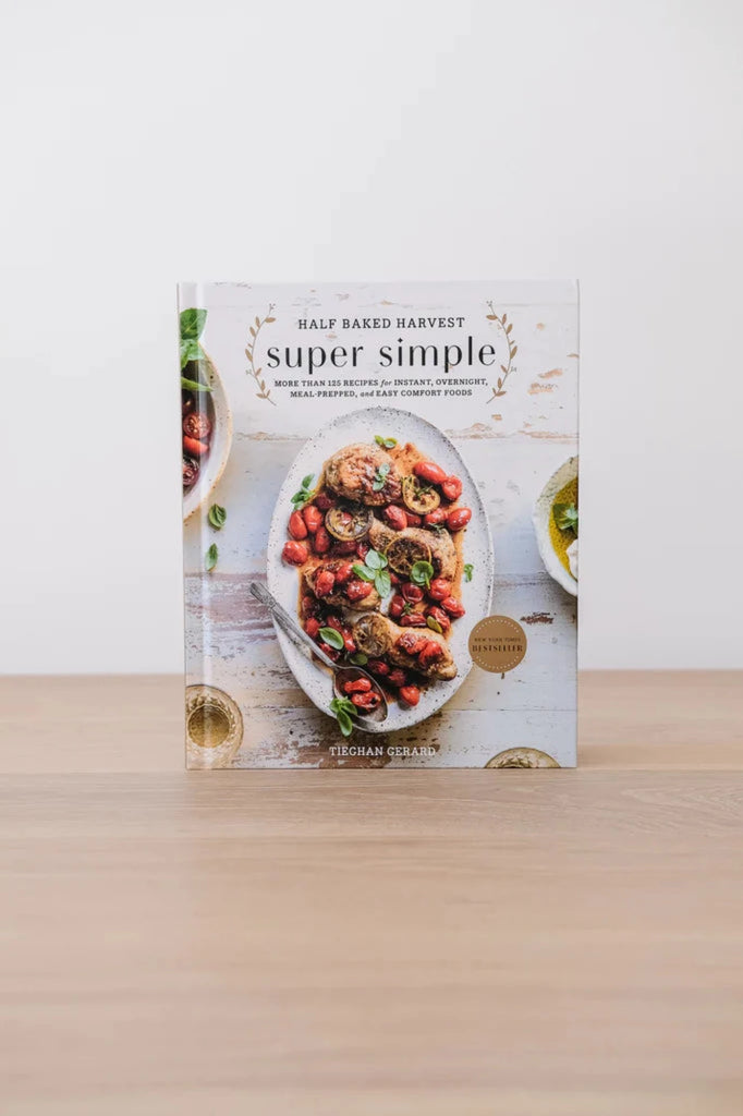 Half Baked Harvest Super Simple cookbook  against white background on an oak table. - Saffron and Poe.