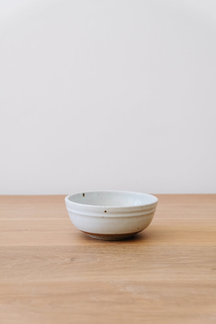 Front view of Hanselmann Ceramic Salt Bowl on an oak table against a white wall. - Saffron and Poe