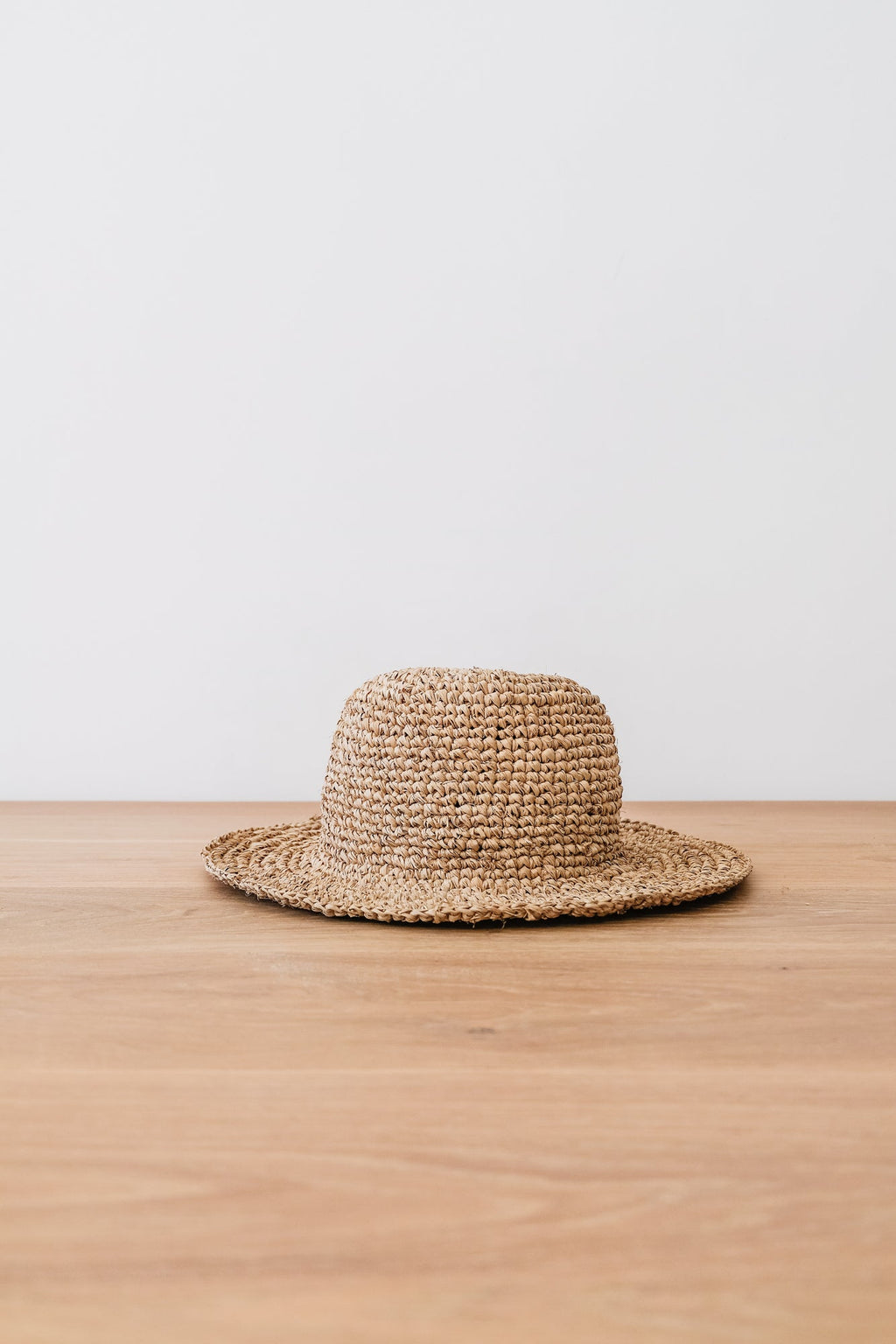 Handwoven Balinese bucket hat made of natural water hyacinth on wooden surface