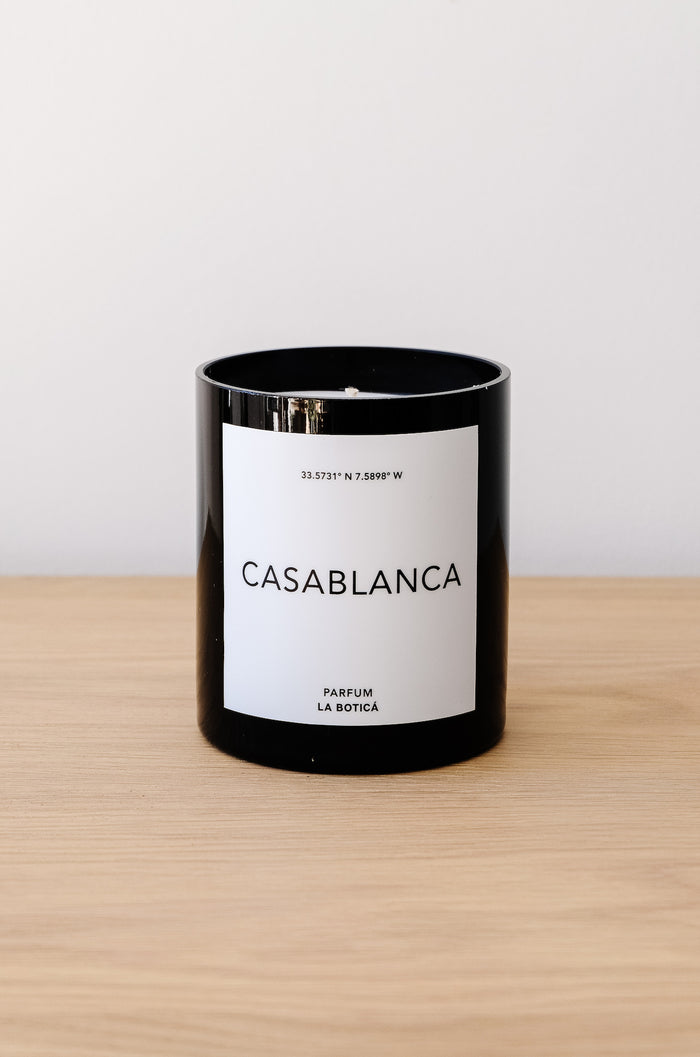Front view of La Botica Casablanca Candle on an oak table against a white wall. - Saffron and Poe