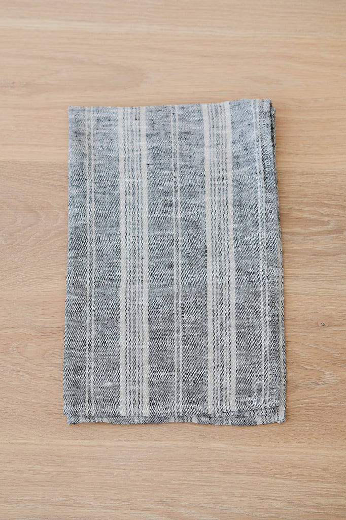Folded Multi-Stripe Linen Hand Towel (Set of 2) on a White Oak Dining Table. - Saffron and Poe