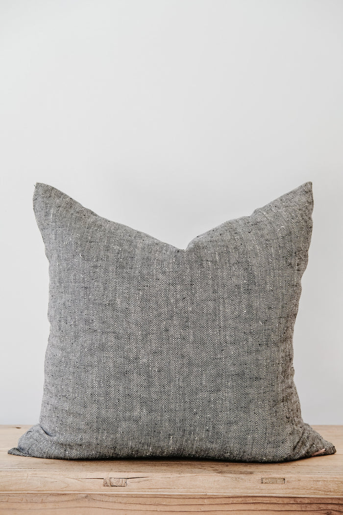 Front view of No. 49 - Chevron Linen Pillow on an Antique Bench against a white wall. - Saffron and Poe