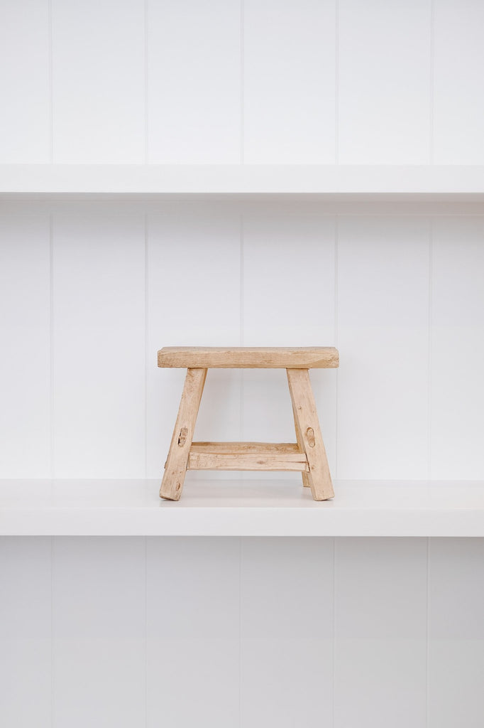 Front view of petite rectangle stool with white background on white shelf. - Saffron and Poe