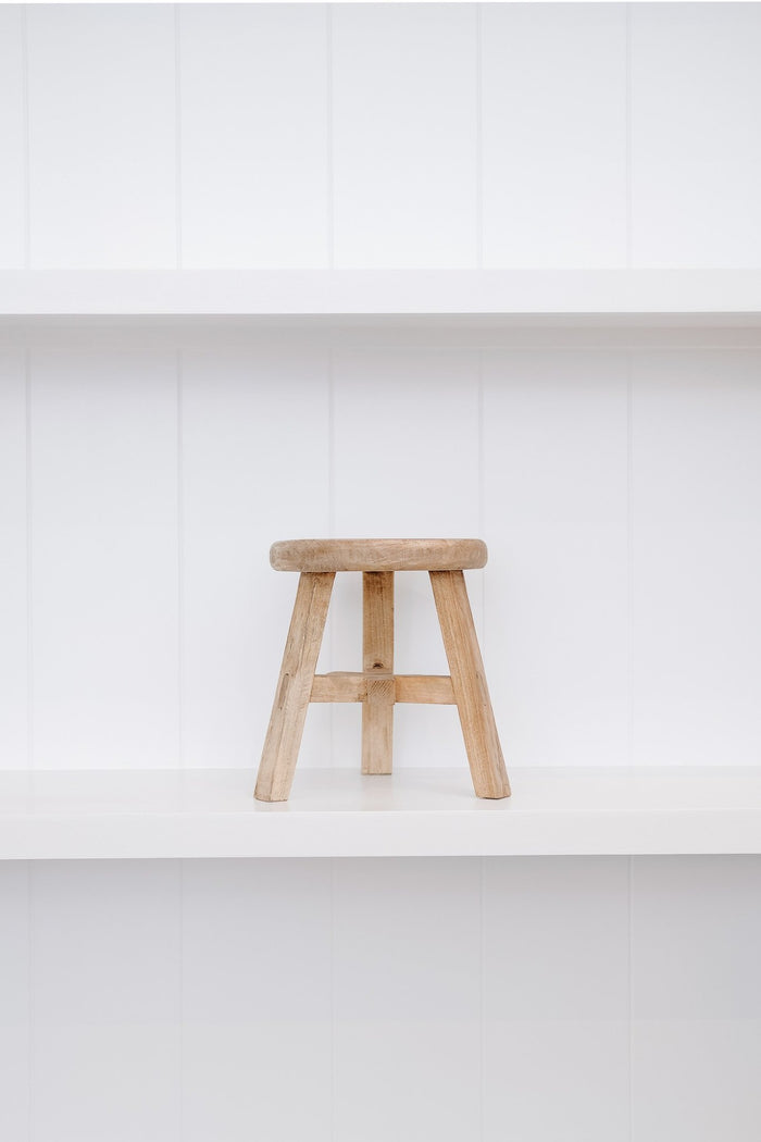 Front view of petite round stool on white shelf against white wood background. - Saffron and Poe