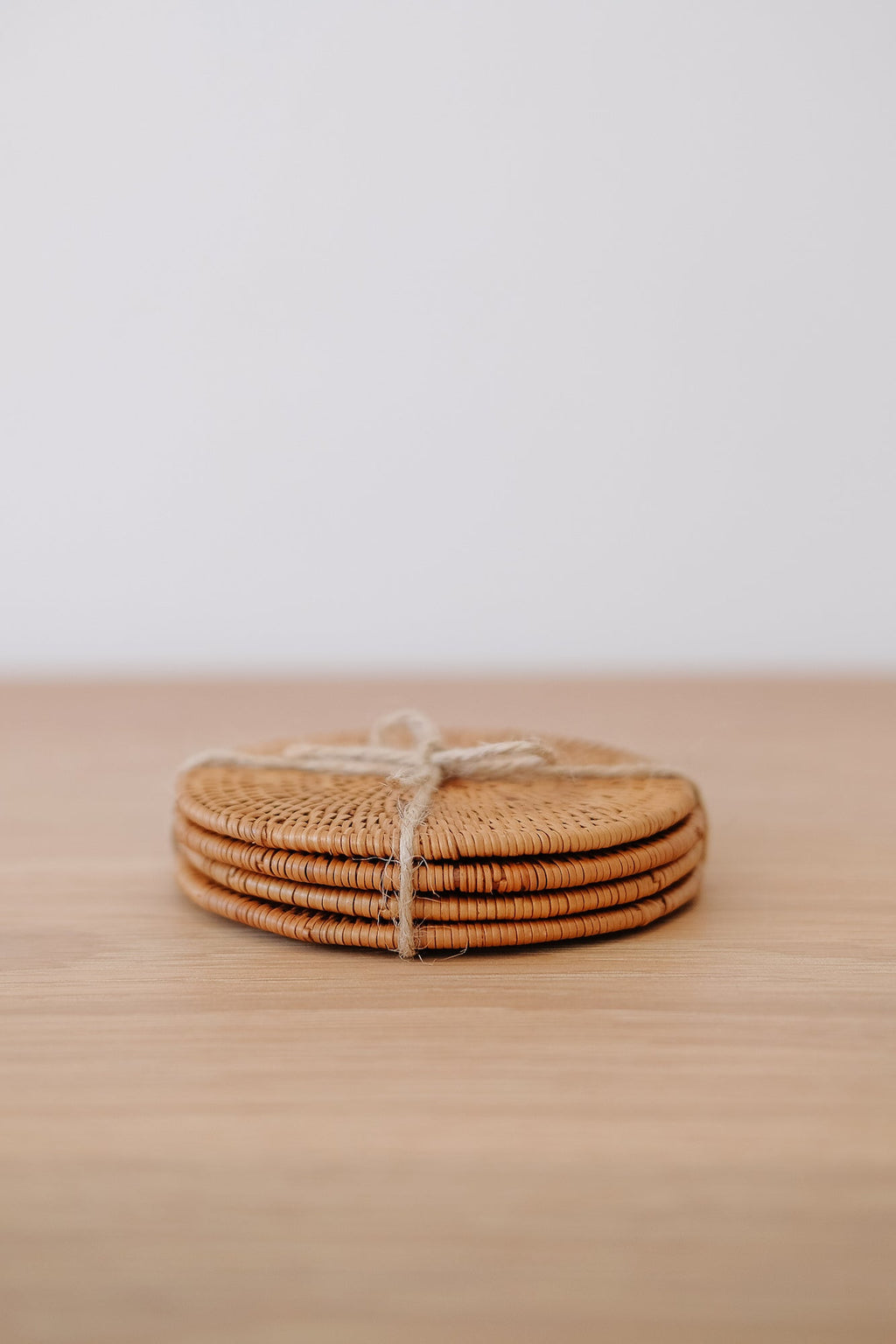 Set of 4 handwoven Tenganan Coasters made from natural Ata reed tied with twine on wooden surface