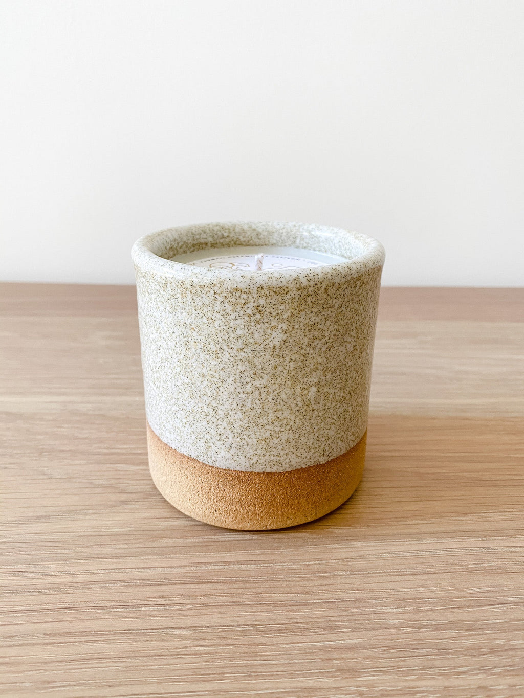 Uzumati Ceramic Bali Moon Candle in rustic stoneware with sand-toned base and speckled white glaze on wooden surface
