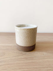 Uzumati Ceramic Coastal Woods Candle in rustic stoneware with speckled white glaze and unglazed deep umber base on wooden surface