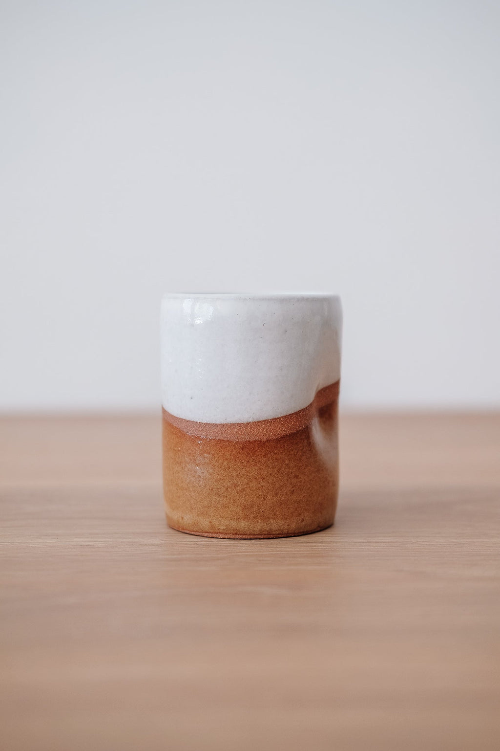 Uzumati Drifter Tumbler with white, rust, and stoneware finish and thumb indention