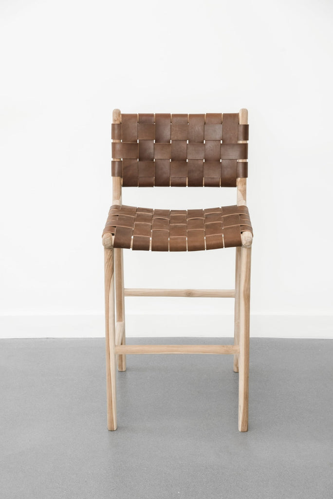 Front facing view of our Woven Leather Strap Counter Stool - Saddle on a white background. Handcrafted in Bali using teak wood and leather. - Saffron and Poe