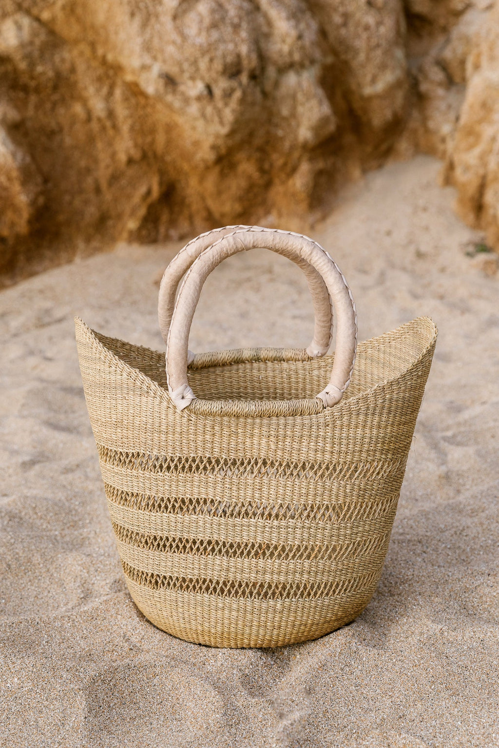 Woven Sisal Farmer's Market Tote with leather handles on sandy surface
