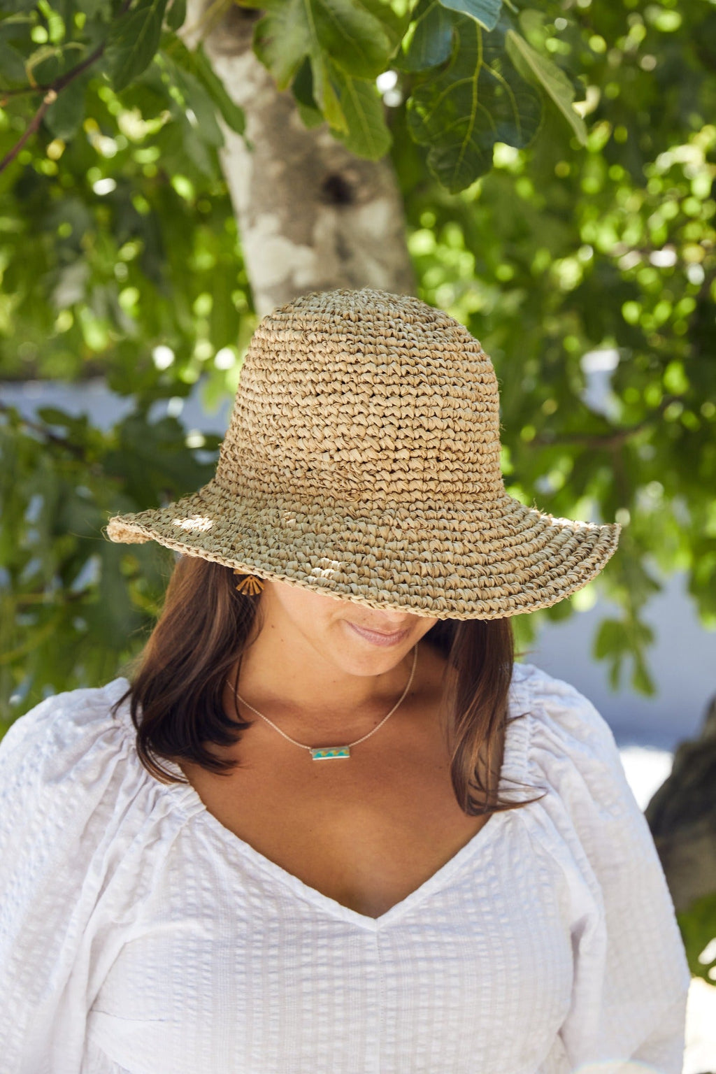 Handwoven Balinese bucket hat made from natural water hyacinth worn by woman outdoors