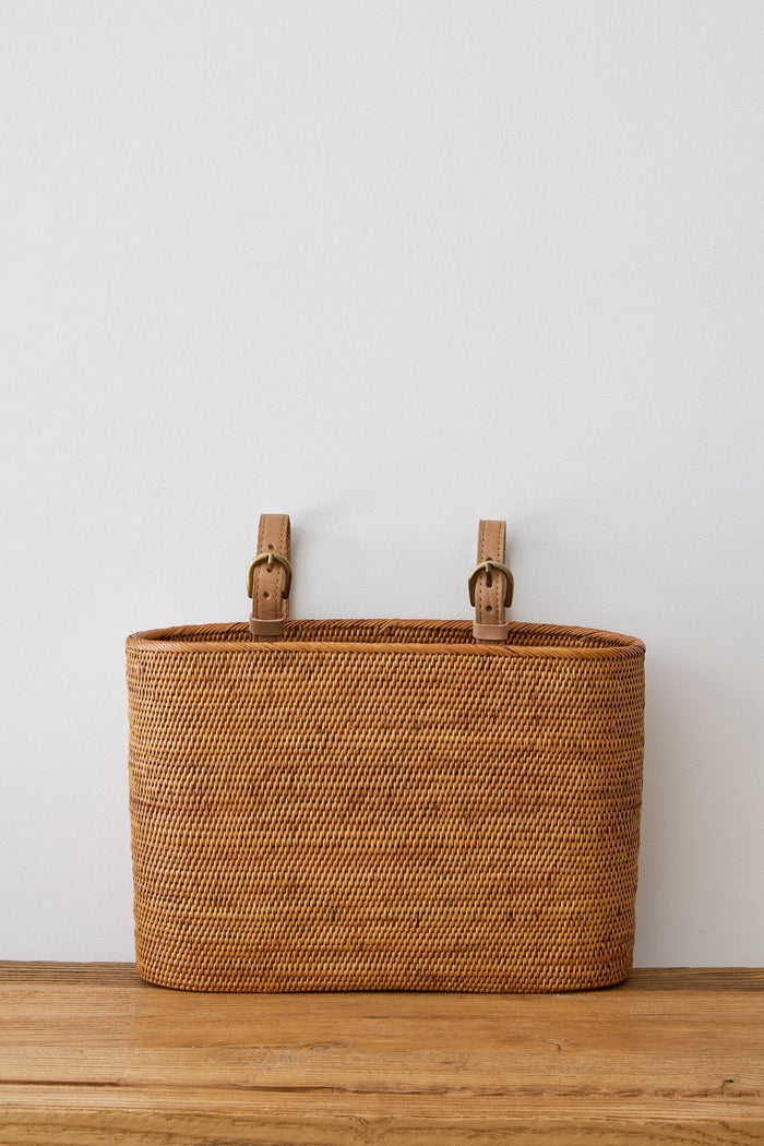Front view of Tenganan Side Basket against white background on an oak table. - Saffron and Poe