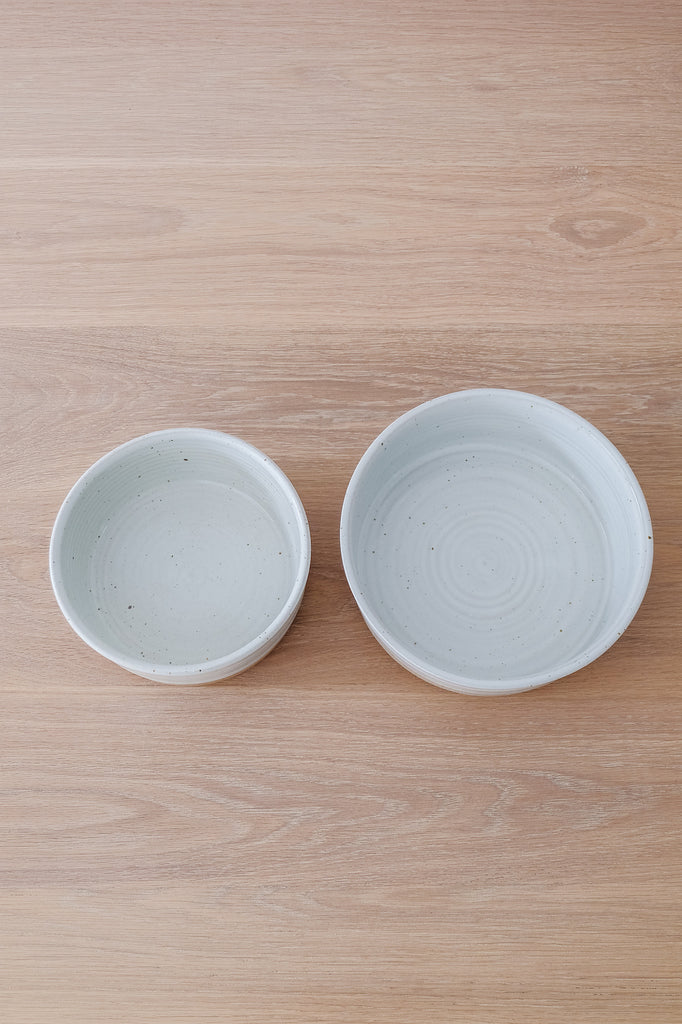 Top down view of Hanselmann Ceramic Dog Bowl Nesting Set of 2 on an oak dining table. - Saffron and Poe