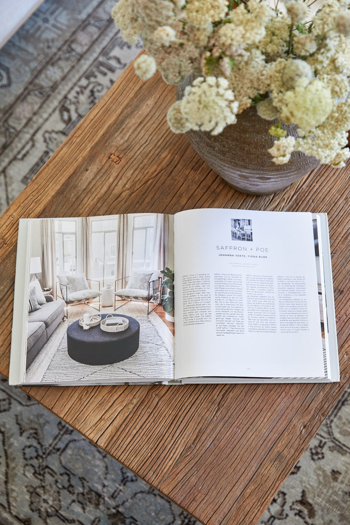 Saffron + Poe feature within open Raw Interiors books on vintage coffee table with side shot of Mijiu vintage vase.