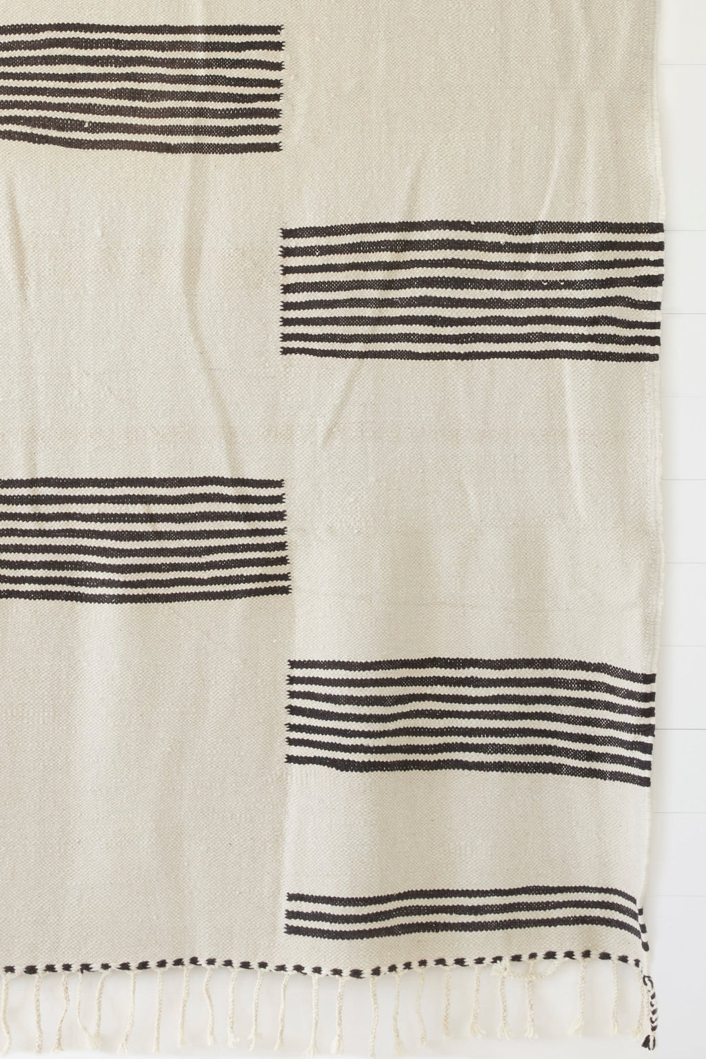 8x12 Moroccan Kilim Rug with bold black geometric stripes and braided fringe on cream background