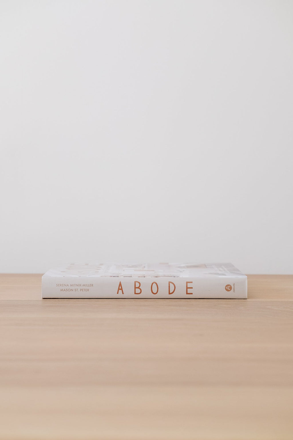 Abode book by Serena Mitnik-Miller and Mason St. Peter on a wooden surface against a plain white wall