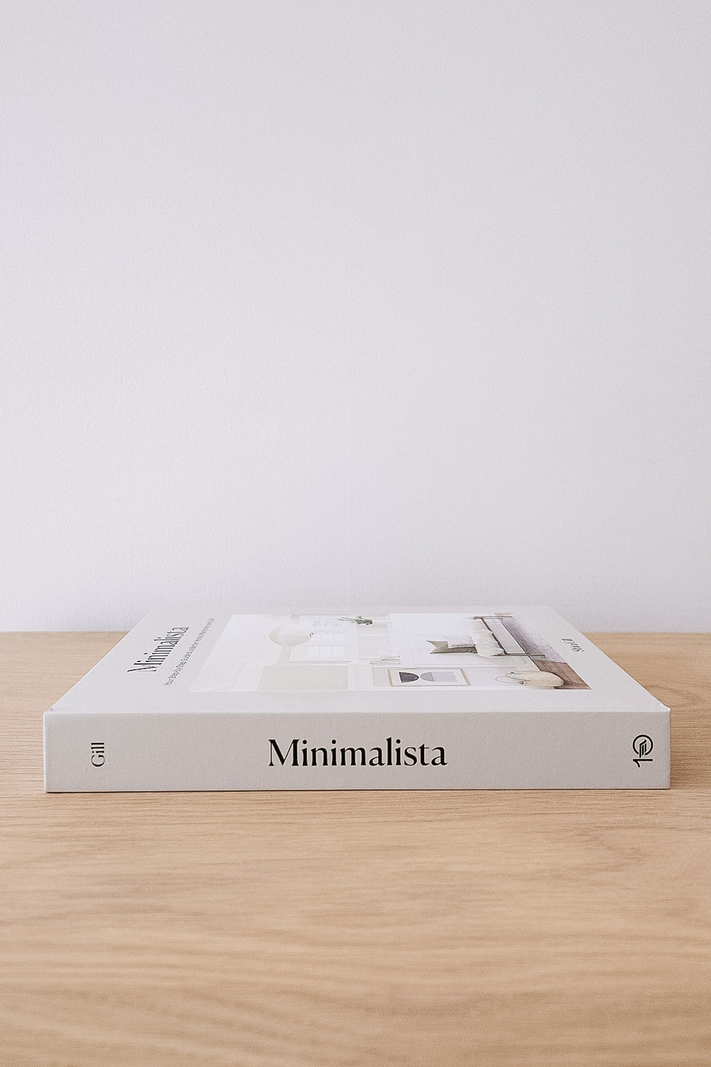 Minimalista book on wooden surface with minimalist white background