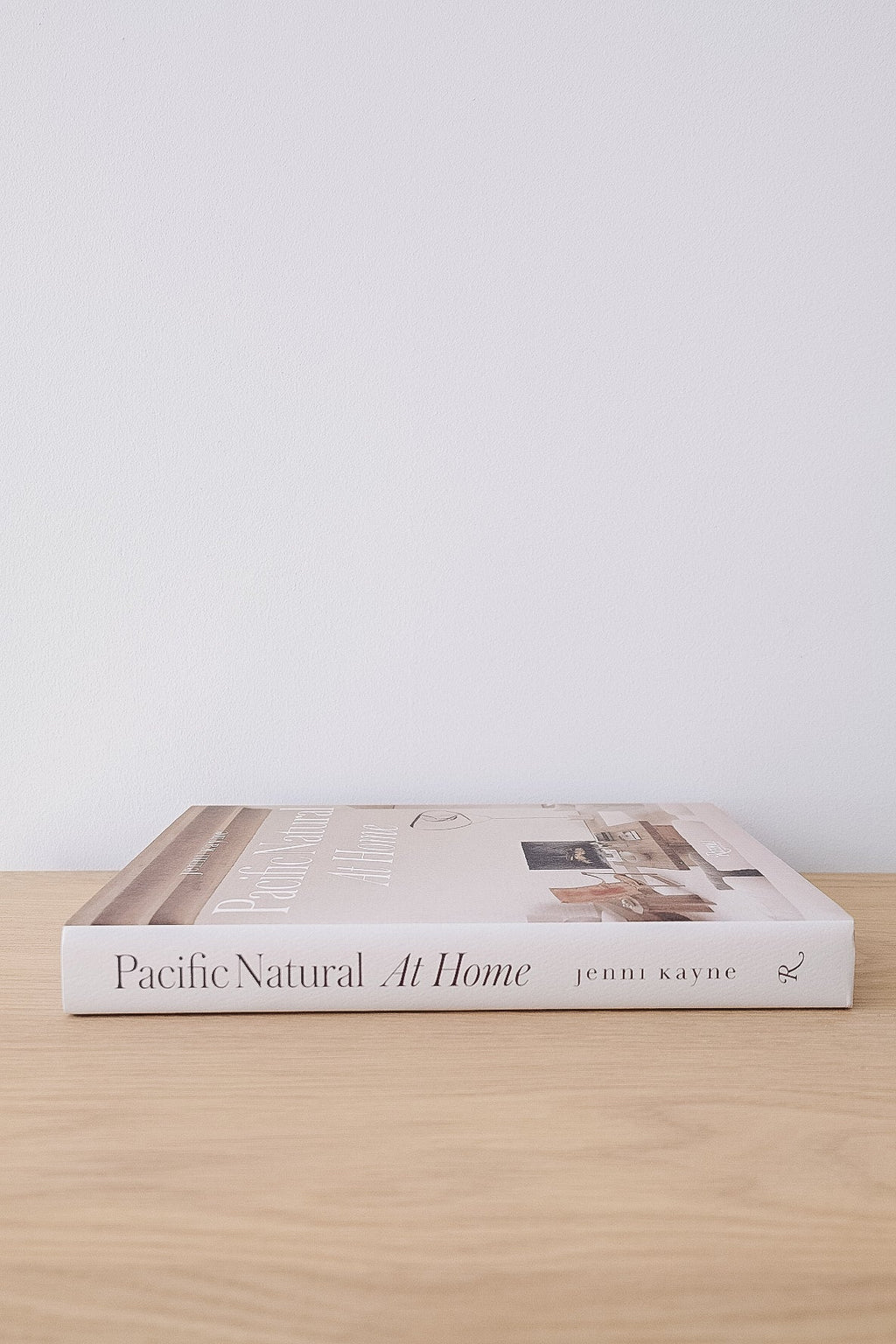 Pacific Natural At Home book by Jenni Kayne on wooden surface with white background