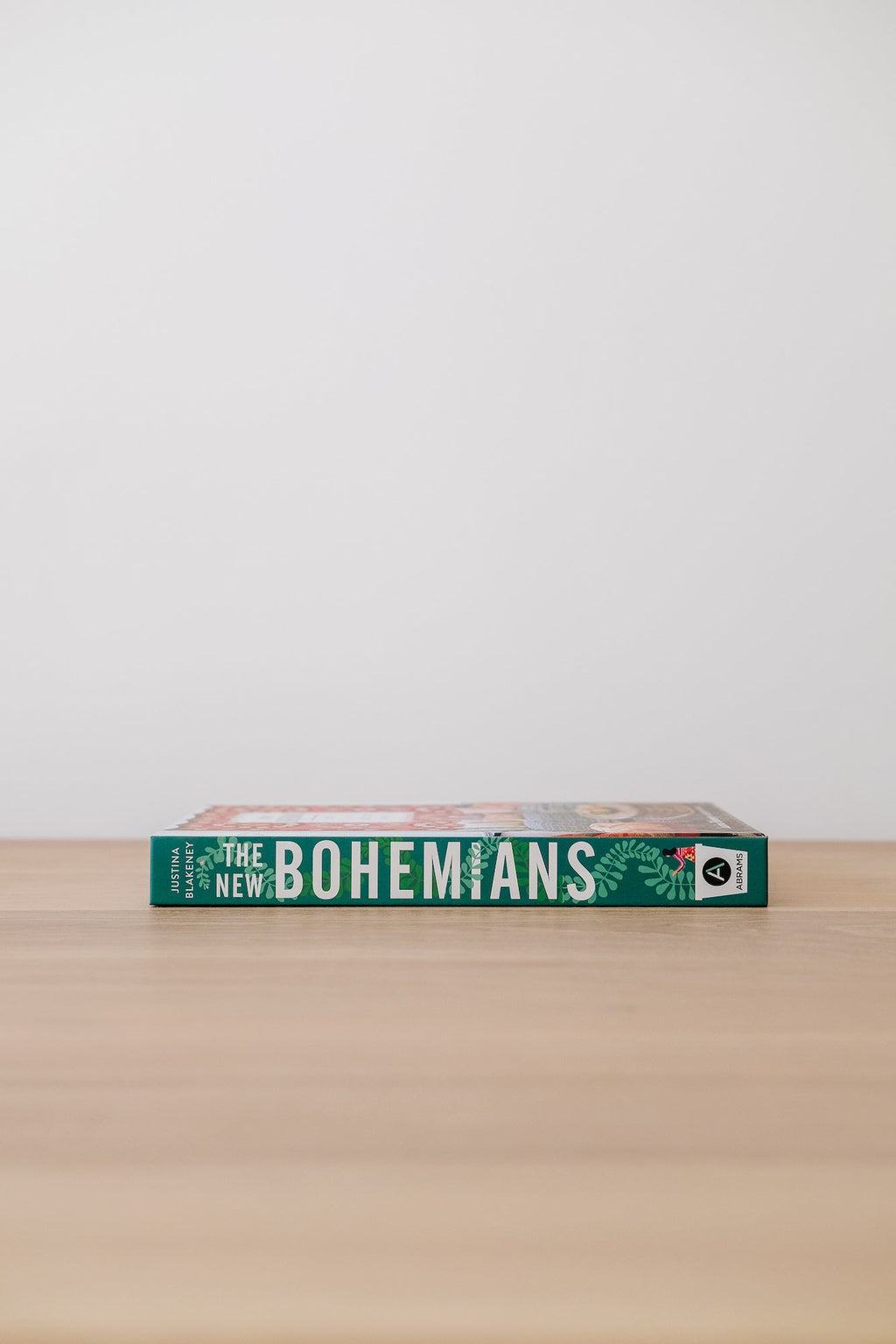 The New Bohemians book lying flat on a wooden surface against a plain white background