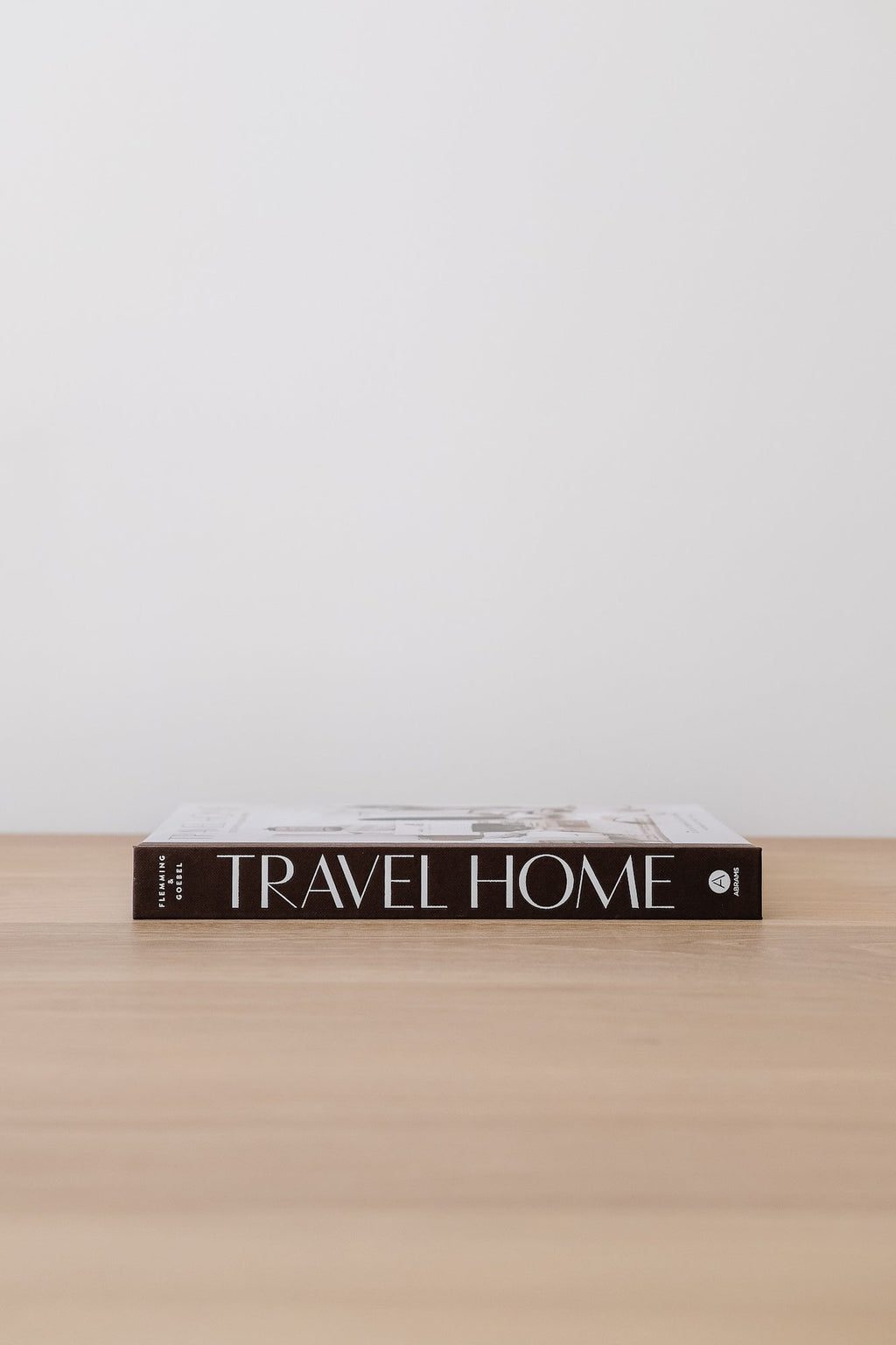 Travel Home book on wooden surface with minimalist background