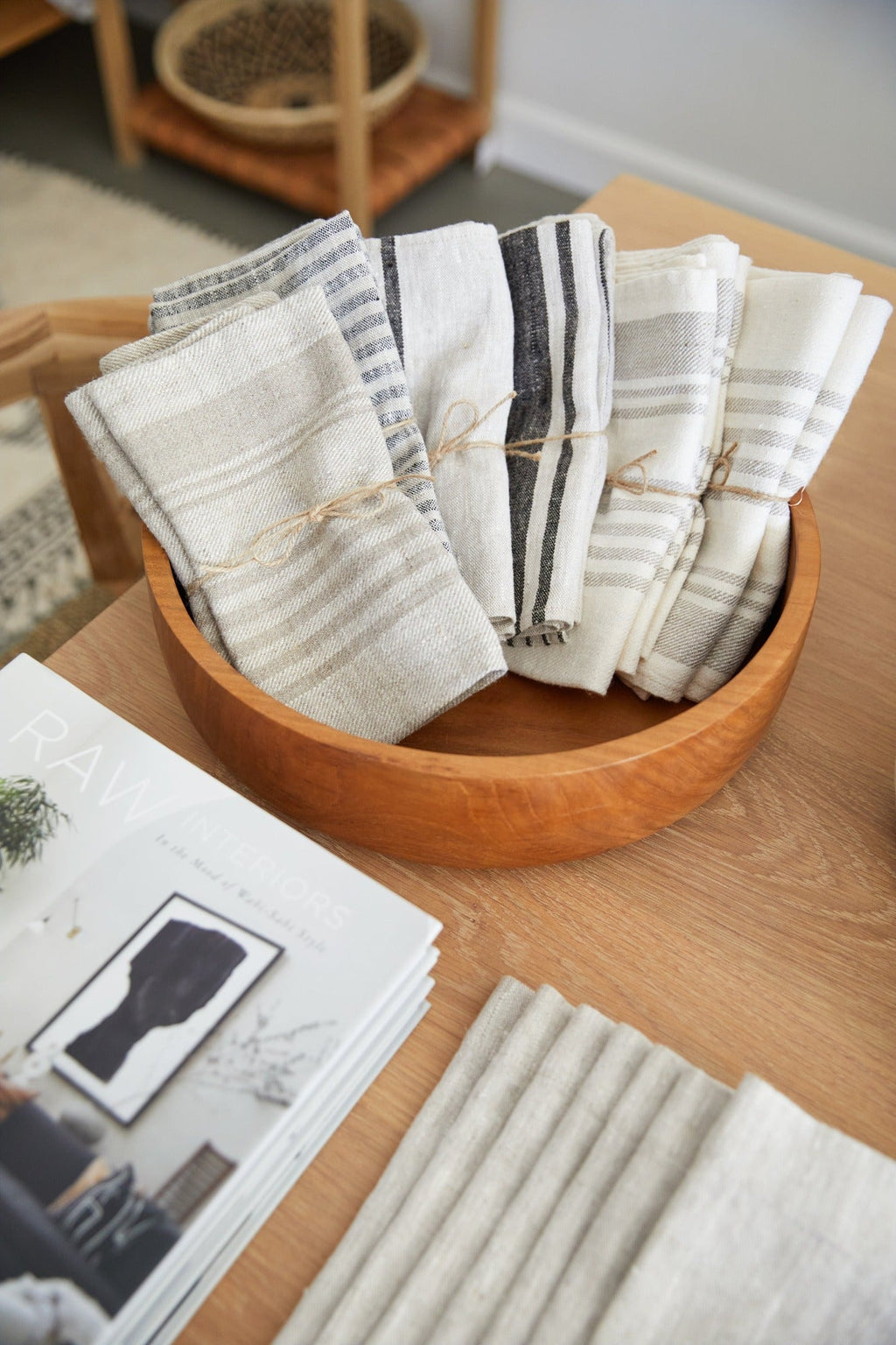 Set of blue and grey stripe linen hand towels in wooden bowl on table