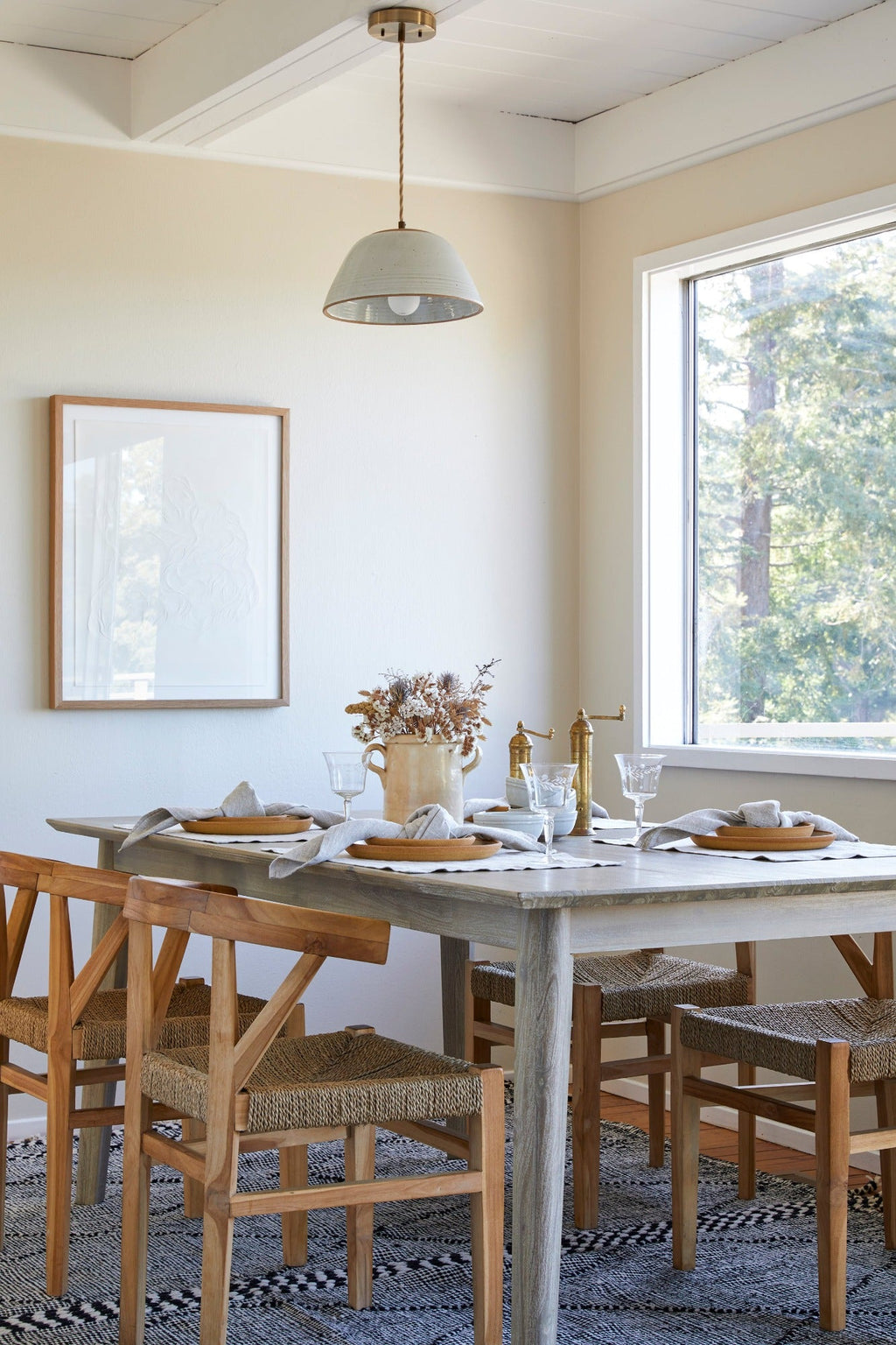 Woven Wishbone Dining Chair with braided rattan seat and teak frame in a bright dining room setting