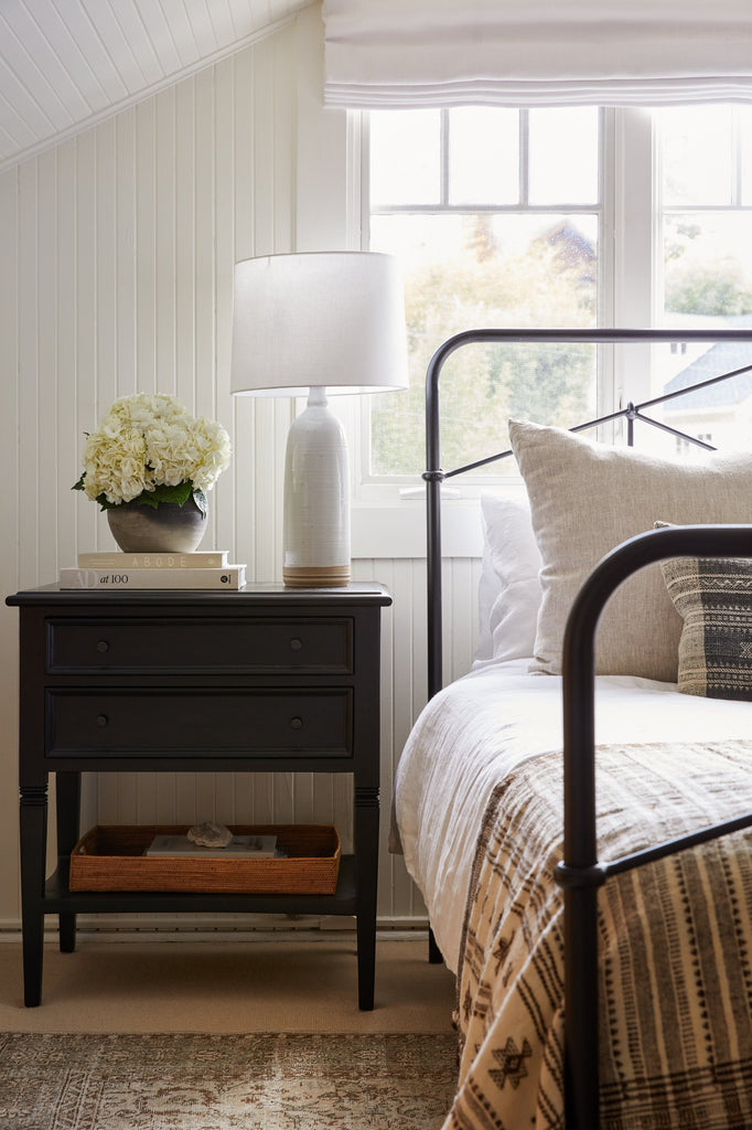 Hand Thrown Ceramic Lamp on a black night stand with Antique Clay Pot, Abode book, and Architectural Digest book. - Saffron + Poe