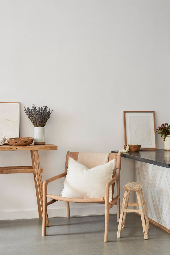 Styled Ivory Alpaca Pillow on a Leather Sling Lounge Chair with an Antique Chinese Stool and a Hand Thrown Ceramic Vase and Tenganan Basket. - Saffron and Poe