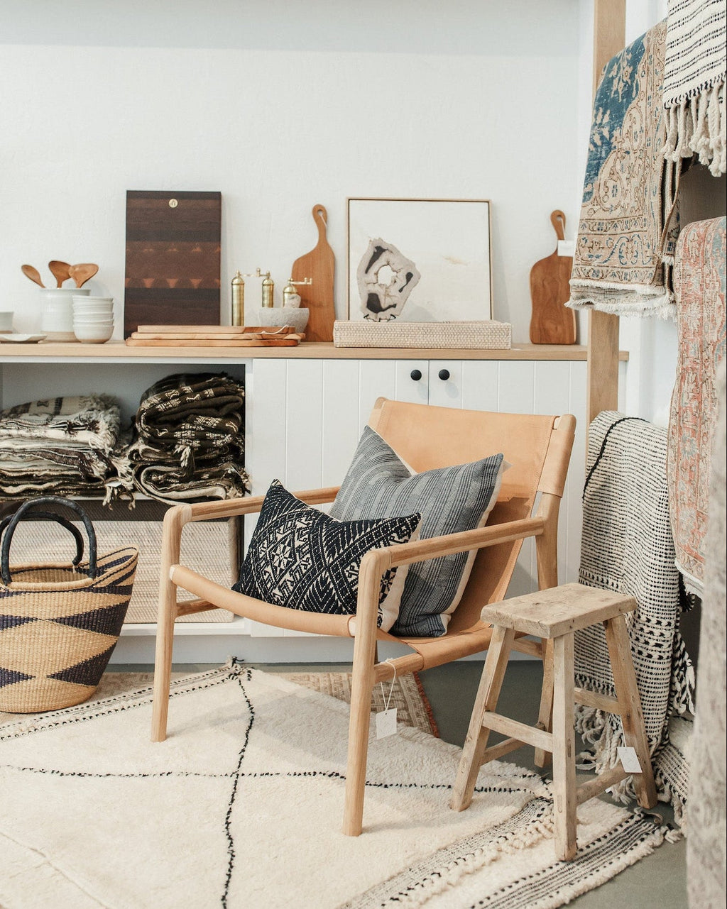 Handcrafted antique stool made of solid elmwood with a rustic patina in a cozy, modern room setting