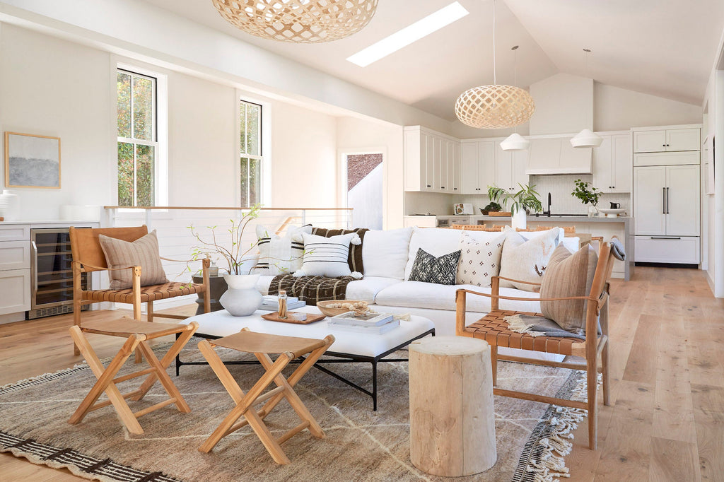 Bright modern living room with Antique Miao lumbar pillow on woven leather chairs and white sofa