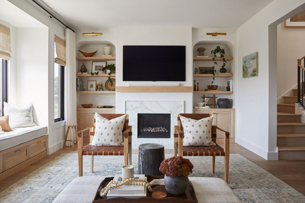 Modern living room with brown checkered pillows on wooden chairs and neutral decor